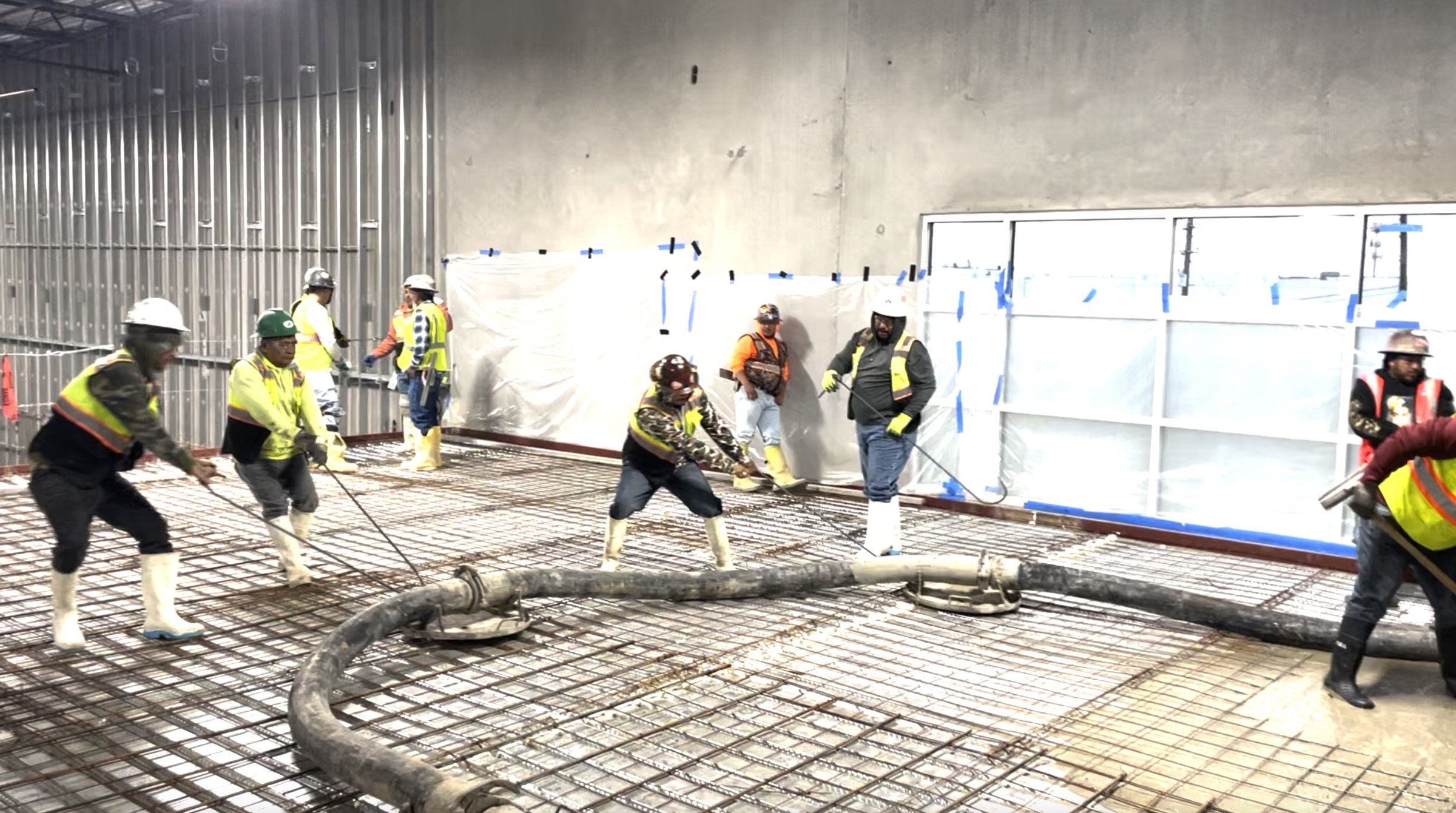 Trillium crew pulling rebar and working a concrete hose on a commercial slab pour